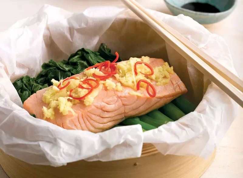 Hấp chín cá hồi với gừng tươi giúp giữ trọn độ mềm ngọt tự nhiên của thịt cá.